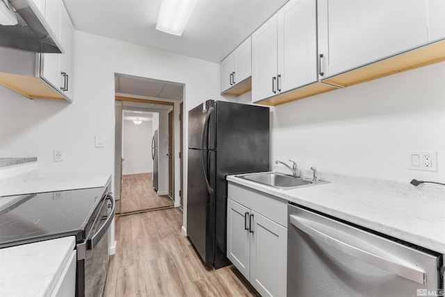 kitchen featuring white cabinets, light hardwood / wood-style floors, stainless steel dishwasher, and extractor fan