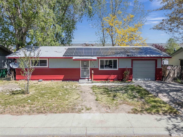 ranch-style house with a front lawn, a garage, and solar panels