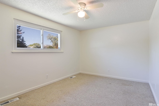 carpeted empty room with a textured ceiling and ceiling fan