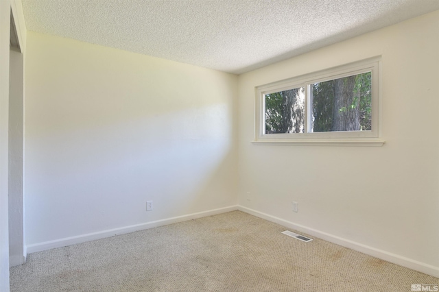 carpeted spare room with a textured ceiling