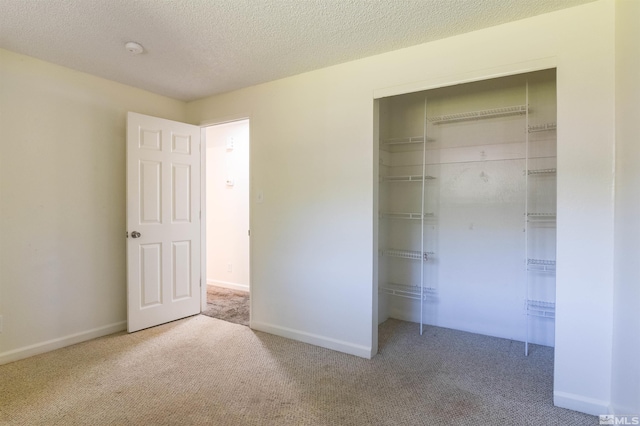 unfurnished bedroom with a closet, carpet, and a textured ceiling