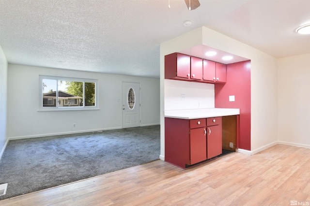 kitchen with a textured ceiling, light hardwood / wood-style flooring, and ceiling fan