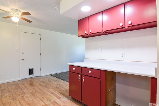 kitchen featuring ceiling fan, light wood-type flooring, and a textured ceiling