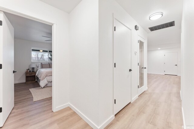 hallway with light hardwood / wood-style floors