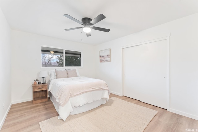 bedroom featuring ceiling fan, light wood-type flooring, and a closet