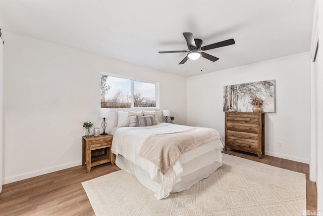 bedroom with ceiling fan and light hardwood / wood-style floors