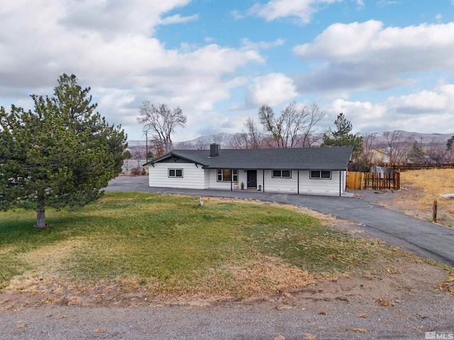 ranch-style home with a mountain view and a front lawn