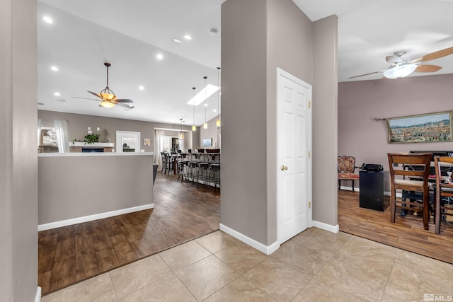 interior space featuring ceiling fan, lofted ceiling, and light wood-type flooring