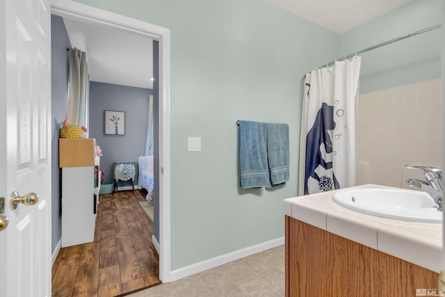 bathroom featuring a shower with shower curtain, wood-type flooring, and sink