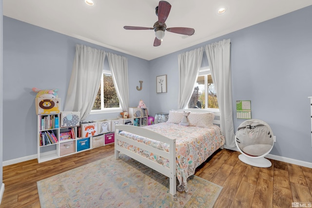 bedroom featuring hardwood / wood-style flooring, multiple windows, and ceiling fan