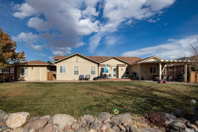 back of house featuring a patio area and a lawn