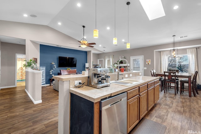 kitchen with dark hardwood / wood-style flooring, stainless steel dishwasher, a kitchen island with sink, and lofted ceiling with skylight