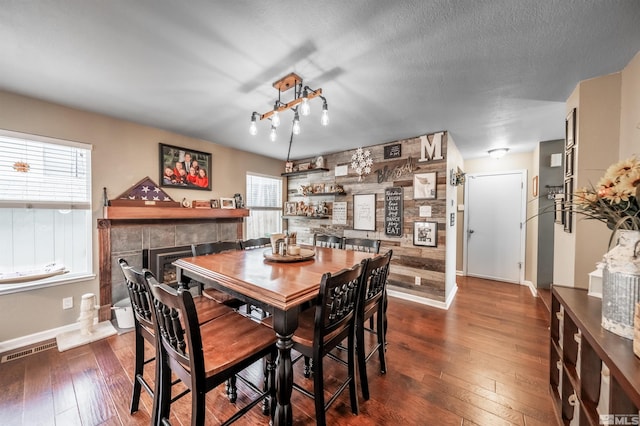 dining space featuring plenty of natural light, dark hardwood / wood-style flooring, and a textured ceiling