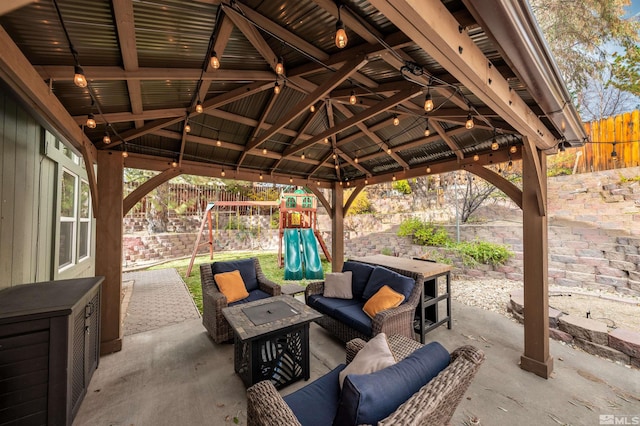 view of patio featuring a gazebo, a playground, and an outdoor living space with a fire pit