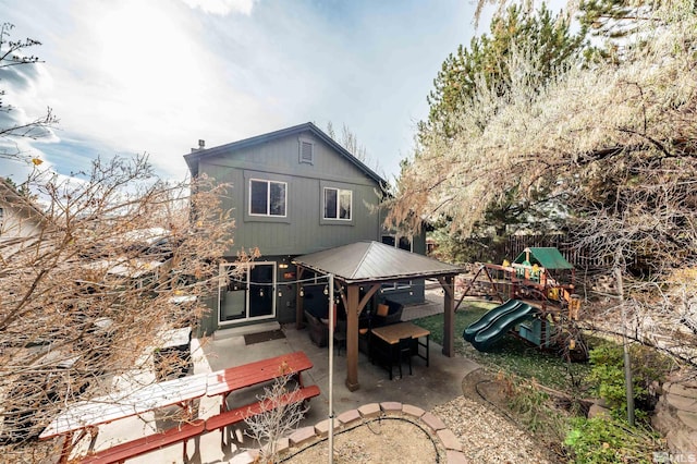 back of house with a playground and a patio