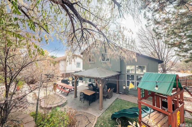 rear view of property featuring a patio, a playground, and an outdoor hangout area