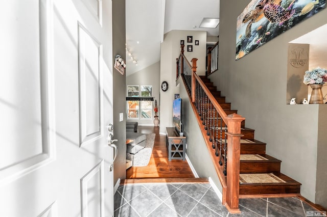 stairs featuring vaulted ceiling and hardwood / wood-style flooring