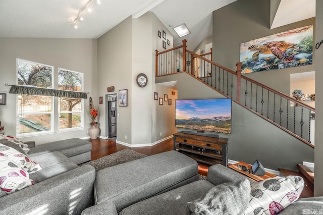 living room with wood-type flooring, rail lighting, and high vaulted ceiling