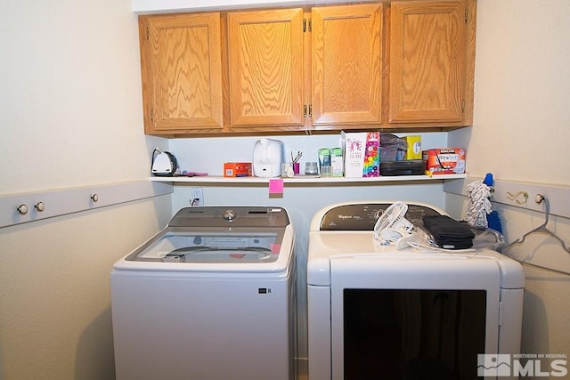 laundry room featuring cabinets and washer and clothes dryer