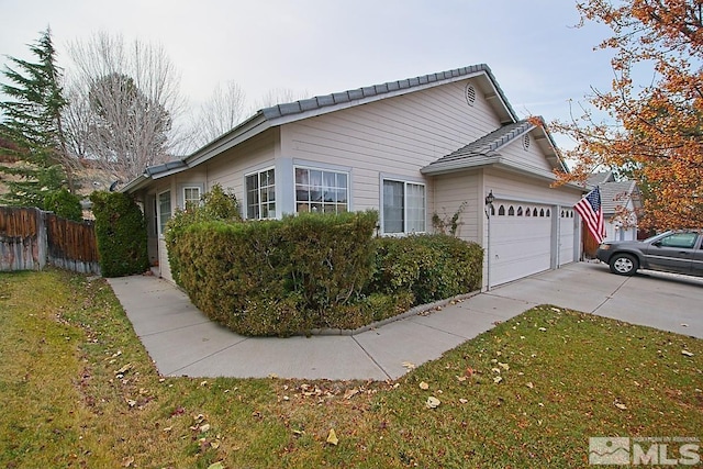 view of home's exterior with a garage and a yard