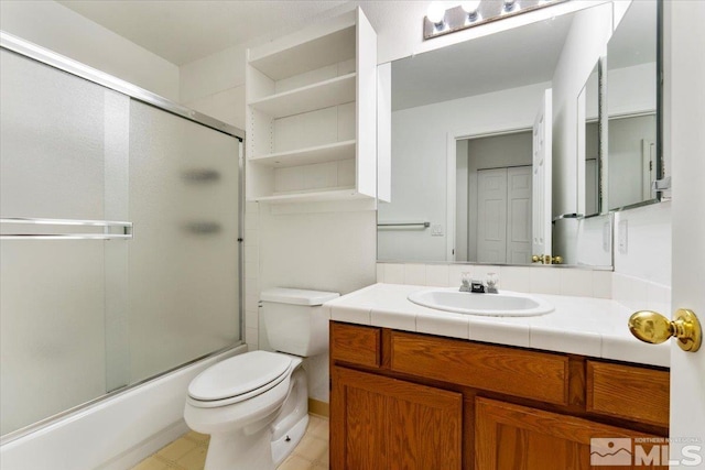 full bathroom with enclosed tub / shower combo, vanity, and toilet