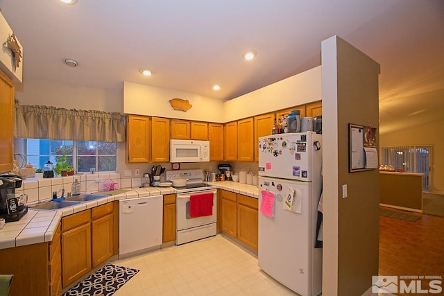 kitchen featuring sink, tile countertops, and white appliances