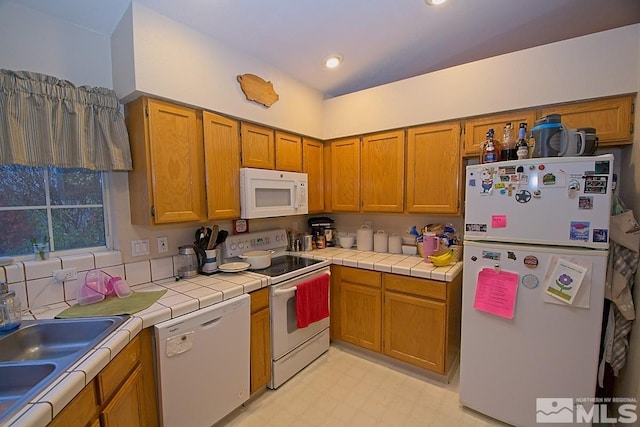 kitchen with sink, tile countertops, and white appliances