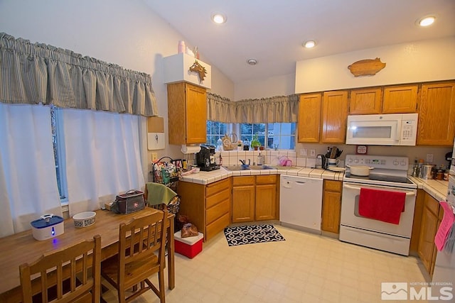 kitchen with sink, white appliances, and tile countertops