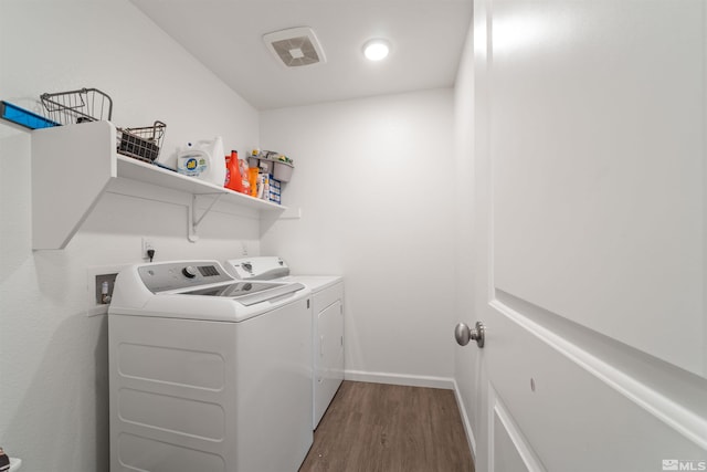 laundry room with dark hardwood / wood-style flooring and washing machine and dryer