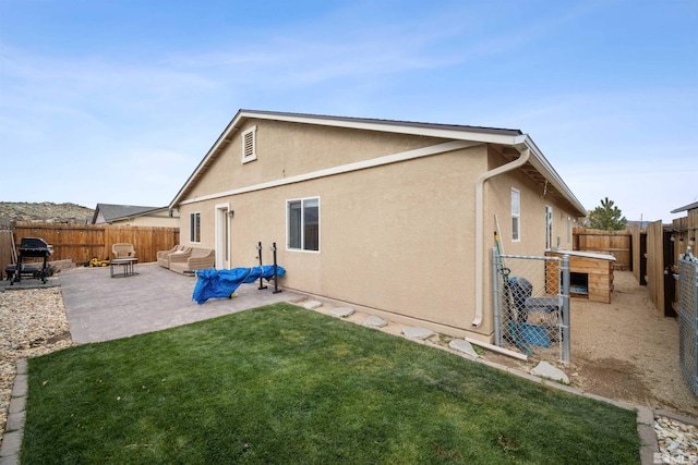 back of house featuring a lawn and a patio