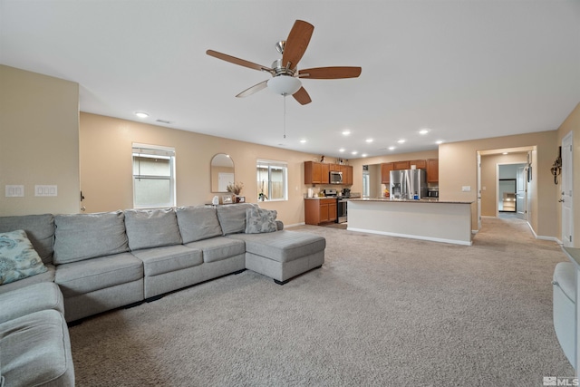 carpeted living room with ceiling fan