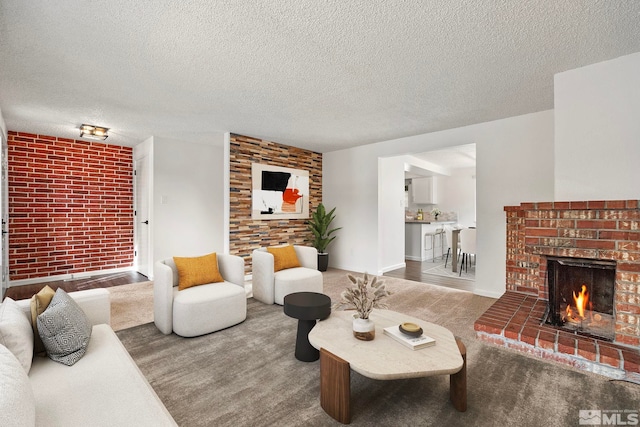 living room with brick wall, a textured ceiling, and a brick fireplace