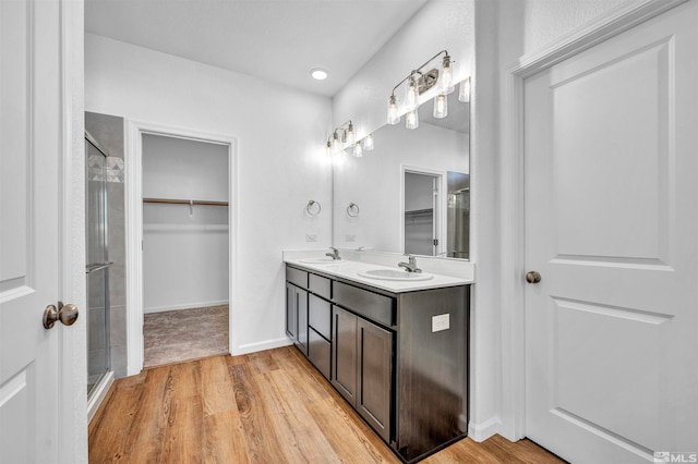 bathroom with hardwood / wood-style flooring, vanity, and a shower with shower door