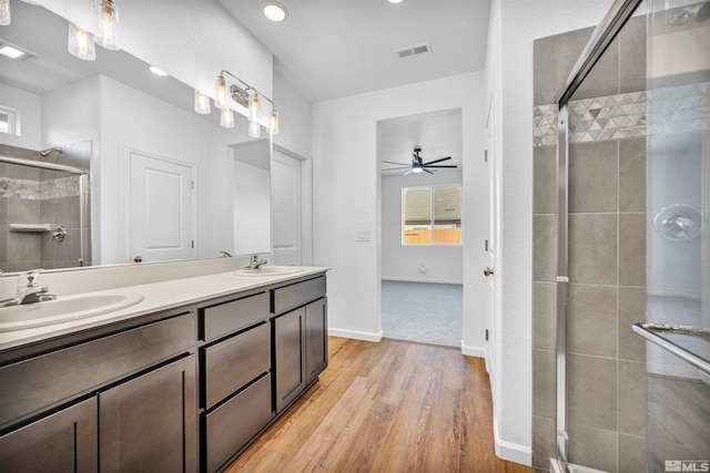 bathroom with wood-type flooring, vanity, ceiling fan, and a shower with shower door