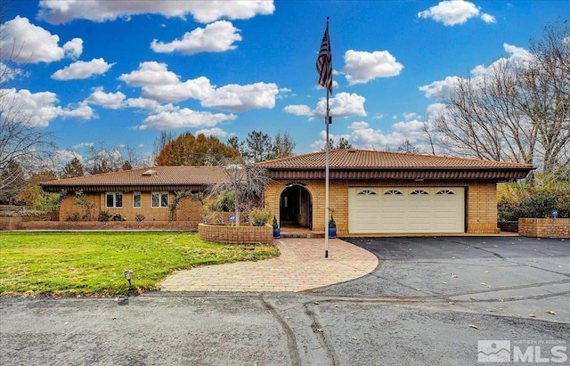 ranch-style house with a garage and a front lawn