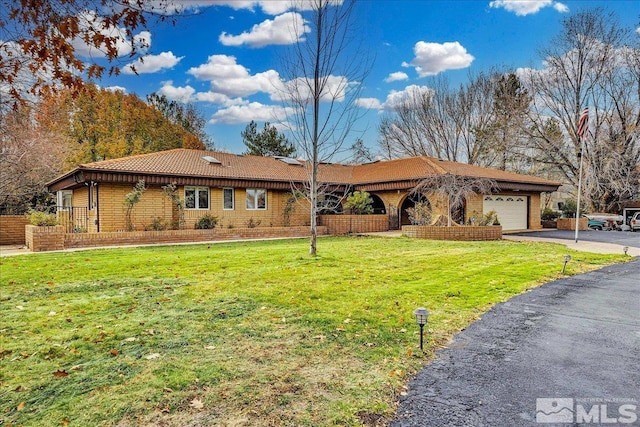 ranch-style house featuring a front yard and a garage