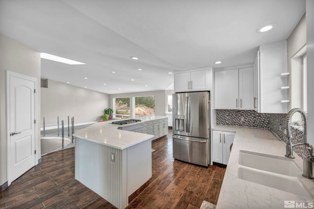 kitchen with white cabinets, sink, dark hardwood / wood-style floors, appliances with stainless steel finishes, and tasteful backsplash