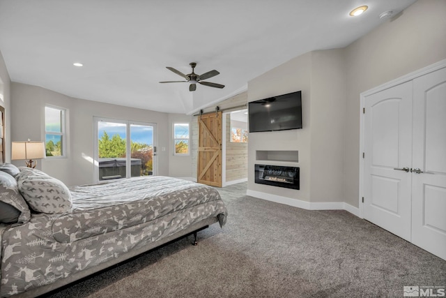 bedroom featuring access to exterior, ceiling fan, a barn door, carpet floors, and lofted ceiling