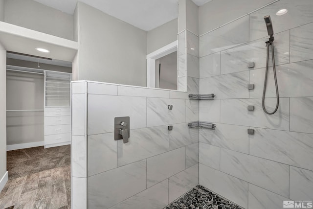 bathroom with hardwood / wood-style flooring and a tile shower