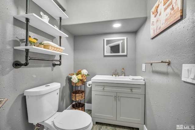 bathroom with vanity, toilet, and wood-type flooring