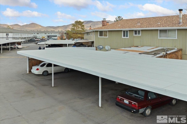 view of parking / parking lot with a mountain view and a carport