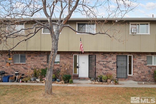 townhome / multi-family property with cooling unit and a front yard