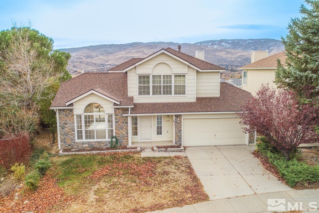 view of front property with a mountain view and a garage