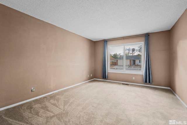 carpeted spare room with a textured ceiling