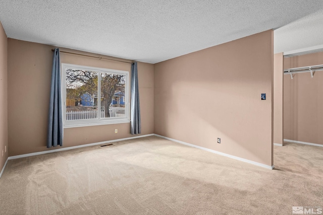 carpeted spare room with a textured ceiling