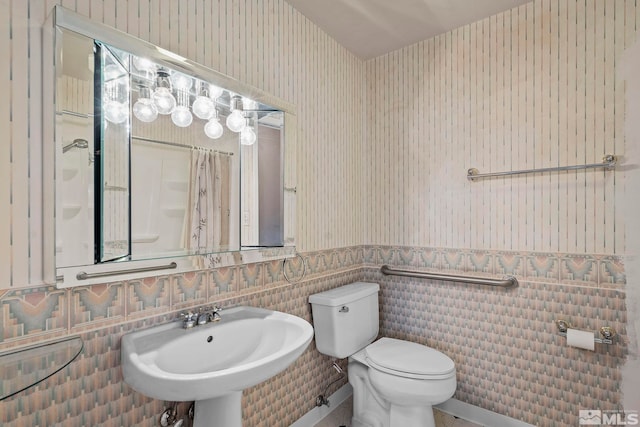 bathroom featuring sink, tile walls, and toilet