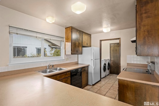 kitchen featuring dishwasher, sink, separate washer and dryer, decorative backsplash, and range