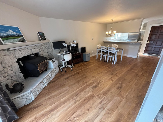 office with hardwood / wood-style flooring, a wood stove, and a notable chandelier