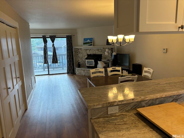 dining space featuring a chandelier, dark hardwood / wood-style flooring, and a wood stove