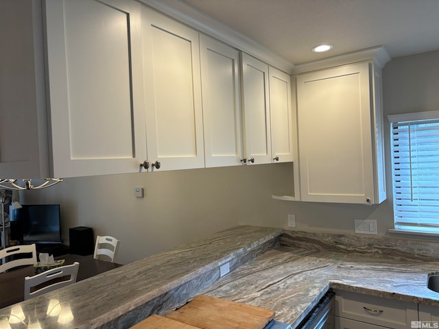 kitchen with white cabinets, dishwasher, and light stone counters